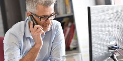 man speaking on the phone with a client | dedicated project management from web development company ABS in Bangalore India